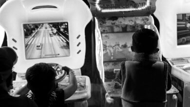 Black and white photo of children playing arcade games, creating a nostalgic feel.