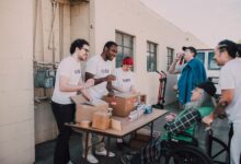 A group of diverse volunteers engaging in a community service activity outdoors, providing aid and support.