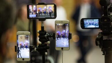 Multiple mobile phones capturing a live event at a prominent landmark in Oslo, Norway.