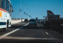 Busy urban expressway filled with vehicles in motion under a clear blue sky, showcasing modern transportation.