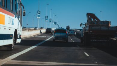Busy urban expressway filled with vehicles in motion under a clear blue sky, showcasing modern transportation.