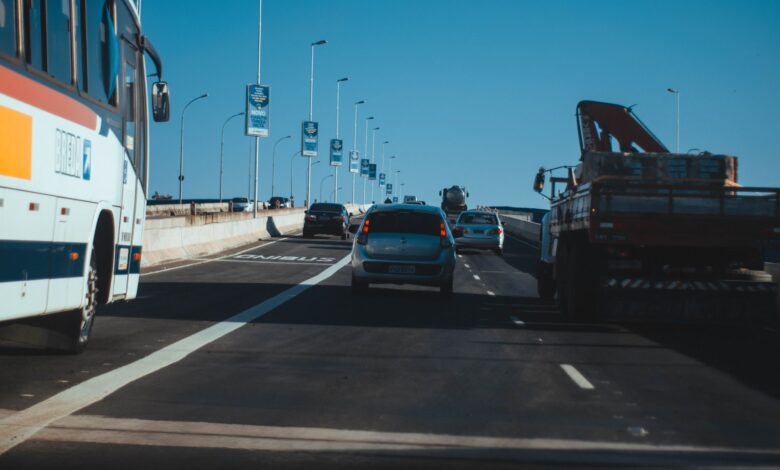 Busy urban expressway filled with vehicles in motion under a clear blue sky, showcasing modern transportation.