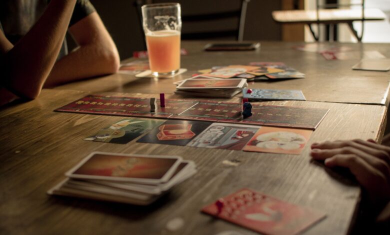 People playing a board game at a café table, capturing leisure and social interaction.