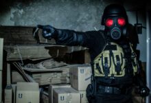 Dark and moody scene of a person in tactical gear and gas mask in an abandoned warehouse.