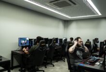 Group of gamers intensely playing video games in a modern esports center.