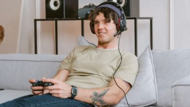 Young man enjoying video gaming session at home with a headset and controller.
