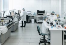 Researchers in lab coats performing experiments with advanced equipment in a laboratory.
