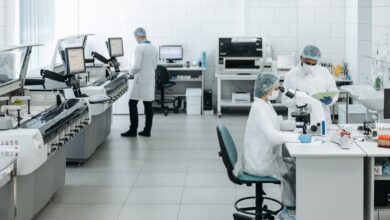 Researchers in lab coats performing experiments with advanced equipment in a laboratory.