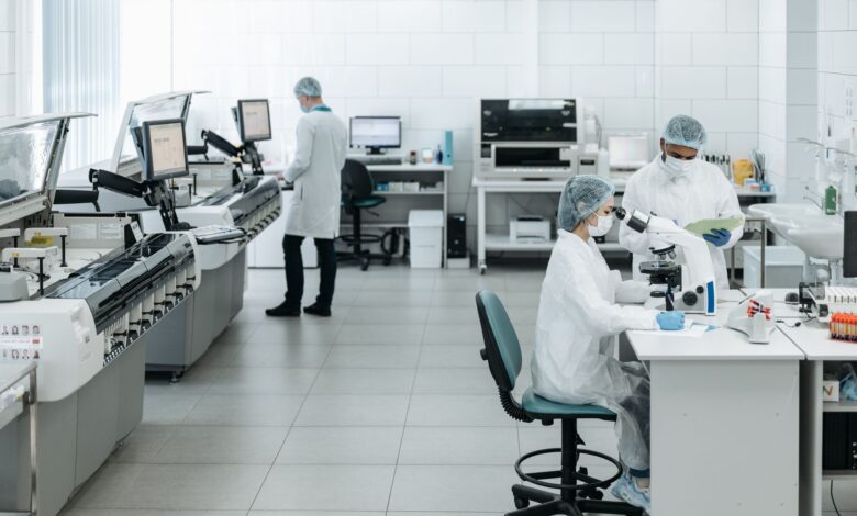 Researchers in lab coats performing experiments with advanced equipment in a laboratory.