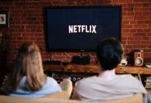 A couple relaxing and watching Netflix in a cozy living room setting.