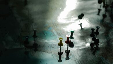 A map with colored pins under dramatic light, highlighting travel planning and destinations.