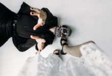 A captivating photoshoot featuring a man with skull makeup in a dynamic pose on a studio floor.