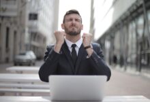 Confident businessman in Budapest celebrates success with a fist pump, reflecting a professional achievement.