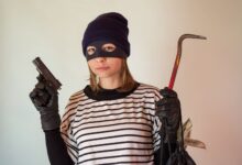 A woman dressed as a robber holding a gun and crowbar, implying criminal activity.