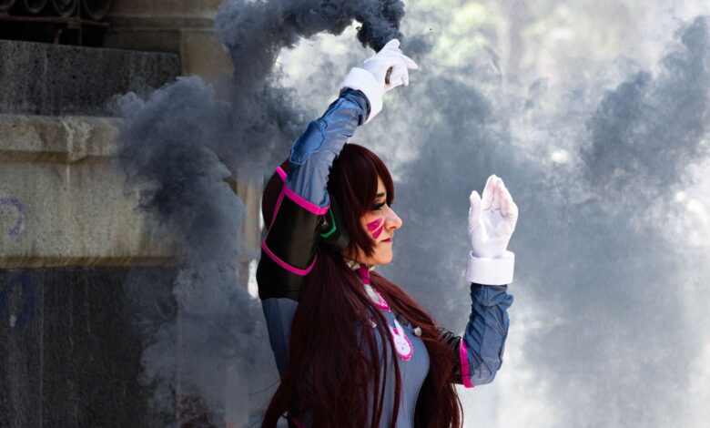A cosplayer dressed in detailed costume poses with smoke in an outdoor setting. Stylish and dynamic scene.