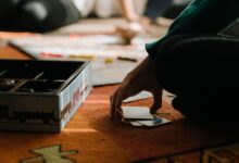 Close-up of hands playing a board game, capturing the strategy and thought involved.