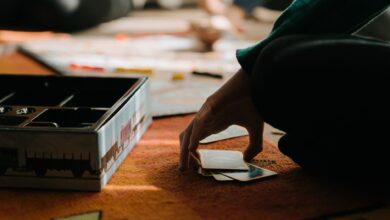 Close-up of hands playing a board game, capturing the strategy and thought involved.
