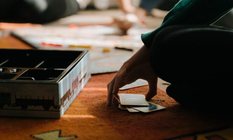 Close-up of hands playing a board game, capturing the strategy and thought involved.