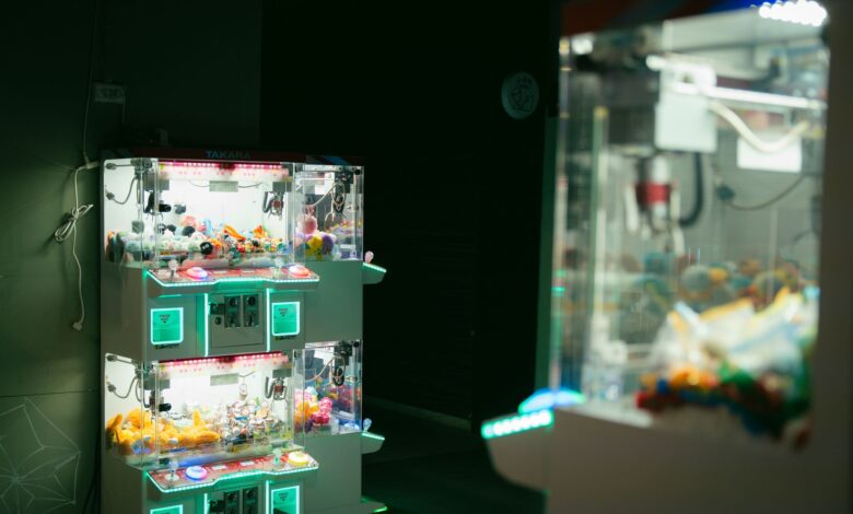Dimly lit arcade featuring claw machines with vibrant neon lighting, capturing modern leisure and gaming.
