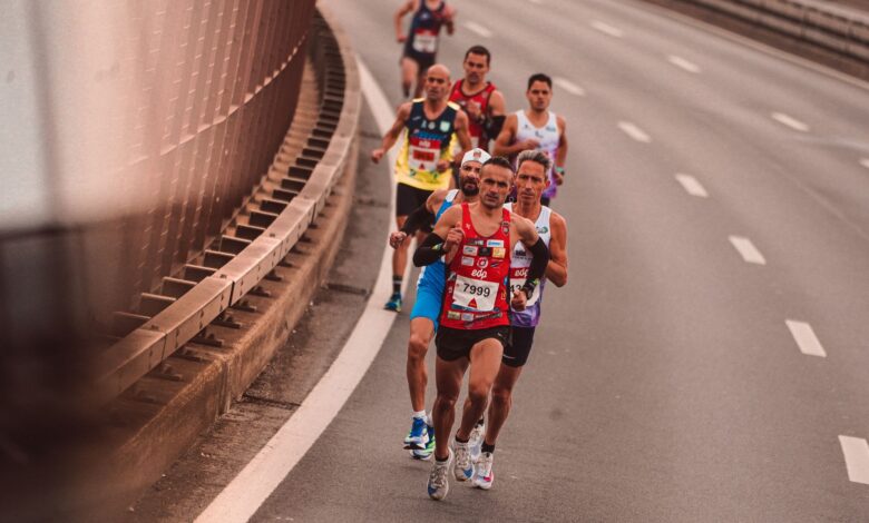 A group of male athletes competing in a city marathon, featuring diverse runners and dynamic movement.