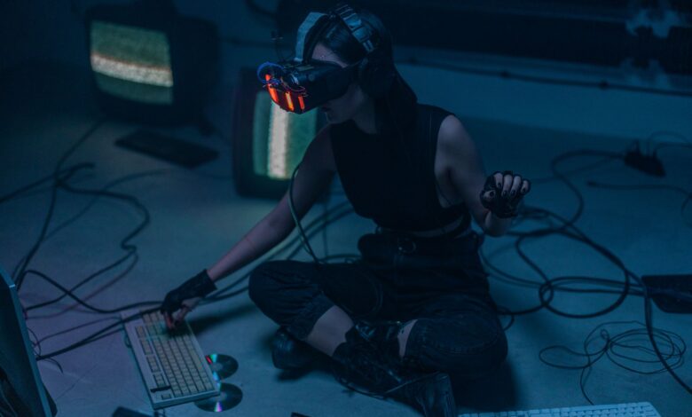 A woman in a VR headset and gloves interacts with technology in a dimly lit room.
