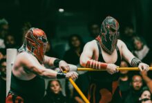 Masked wrestlers compete in an exciting Lucha Libre match before an engaged audience.