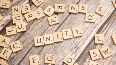 Scrabble tiles on a wooden surface spell 'Unity', highlighting teamwork and togetherness.