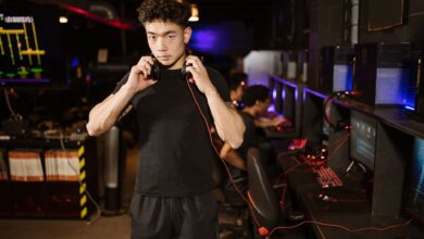 A serious young man in a gaming lounge with headphones, embodying the modern e-sports culture.
