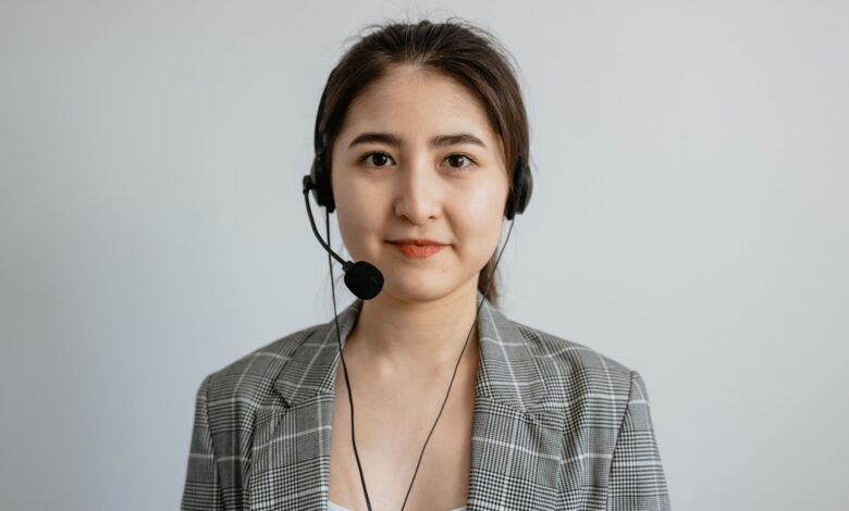 Portrait of a young female call center agent in a professional setting wearing a headset.