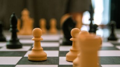 Close-up view of a strategic chess game with focus on pawns and pieces.