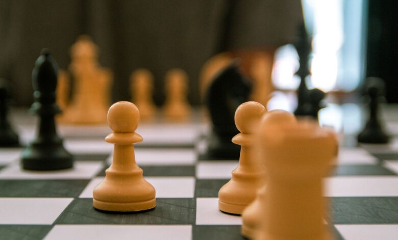 Close-up view of a strategic chess game with focus on pawns and pieces.