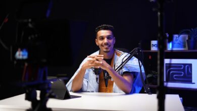 A confident podcaster speaking into a microphone in a modern studio setting.