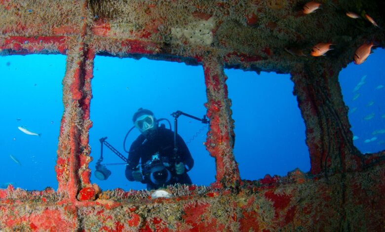 Scuba diver captures images at an underwater shipwreck.