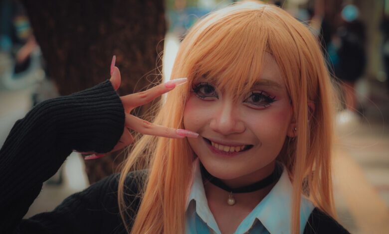 A vibrant cosplay portrait of a young adult in costume posing with a peace sign outdoors.