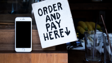A phone next to an 'Order and Pay Here' sign in a cozy indoor setting, perfect for business use.