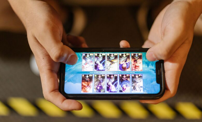 Close-up of hands playing a mobile game on a smartphone, showcasing the game's interface.
