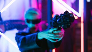A woman in cyberpunk fashion holding a futuristic weapon against a neon backdrop.