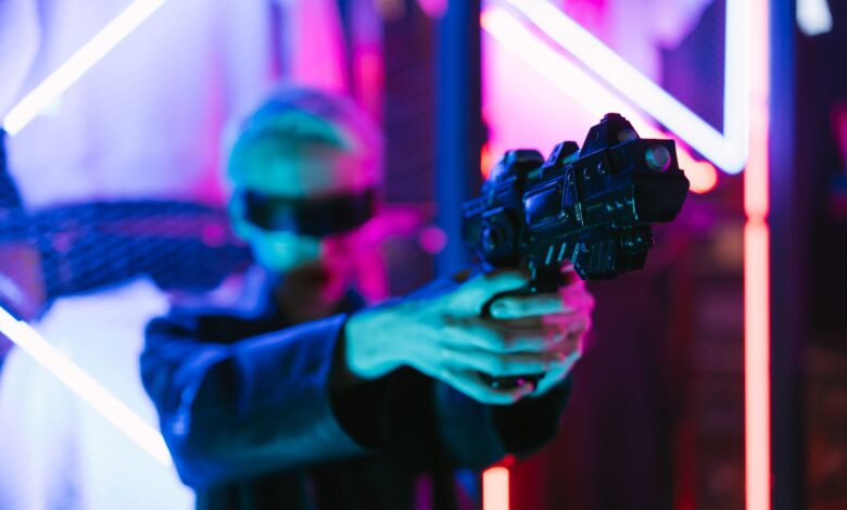 A woman in cyberpunk fashion holding a futuristic weapon against a neon backdrop.