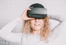 Smiling woman wearing a VR headset and experiencing virtual reality excitement.