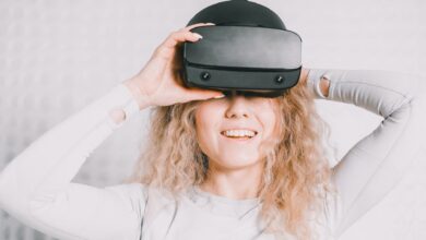 Smiling woman wearing a VR headset and experiencing virtual reality excitement.
