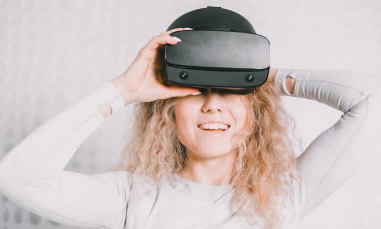 Smiling woman wearing a VR headset and experiencing virtual reality excitement.