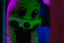 A spooky figure in a costume with dramatic lighting, creating a Halloween atmosphere.