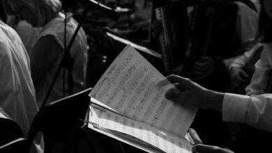 Black and white photo of musicians rehearsing with sheet music.
