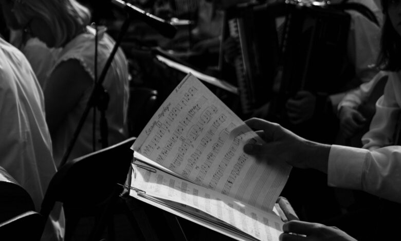 Black and white photo of musicians rehearsing with sheet music.