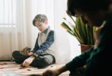 Kids enjoying an indoor tabletop card game in natural light, fostering leisure and strategy skills.