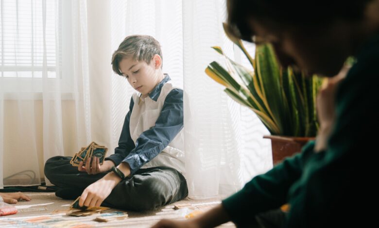 Kids enjoying an indoor tabletop card game in natural light, fostering leisure and strategy skills.