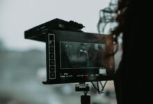 A close-up of professional filming equipment capturing a scene outdoors.