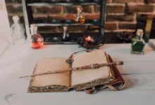 Magical close-up of a wand on an ancient spell book with potions.