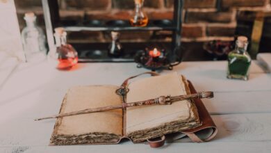 Magical close-up of a wand on an ancient spell book with potions.