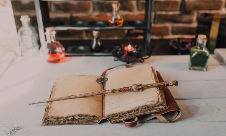 Magical close-up of a wand on an ancient spell book with potions.